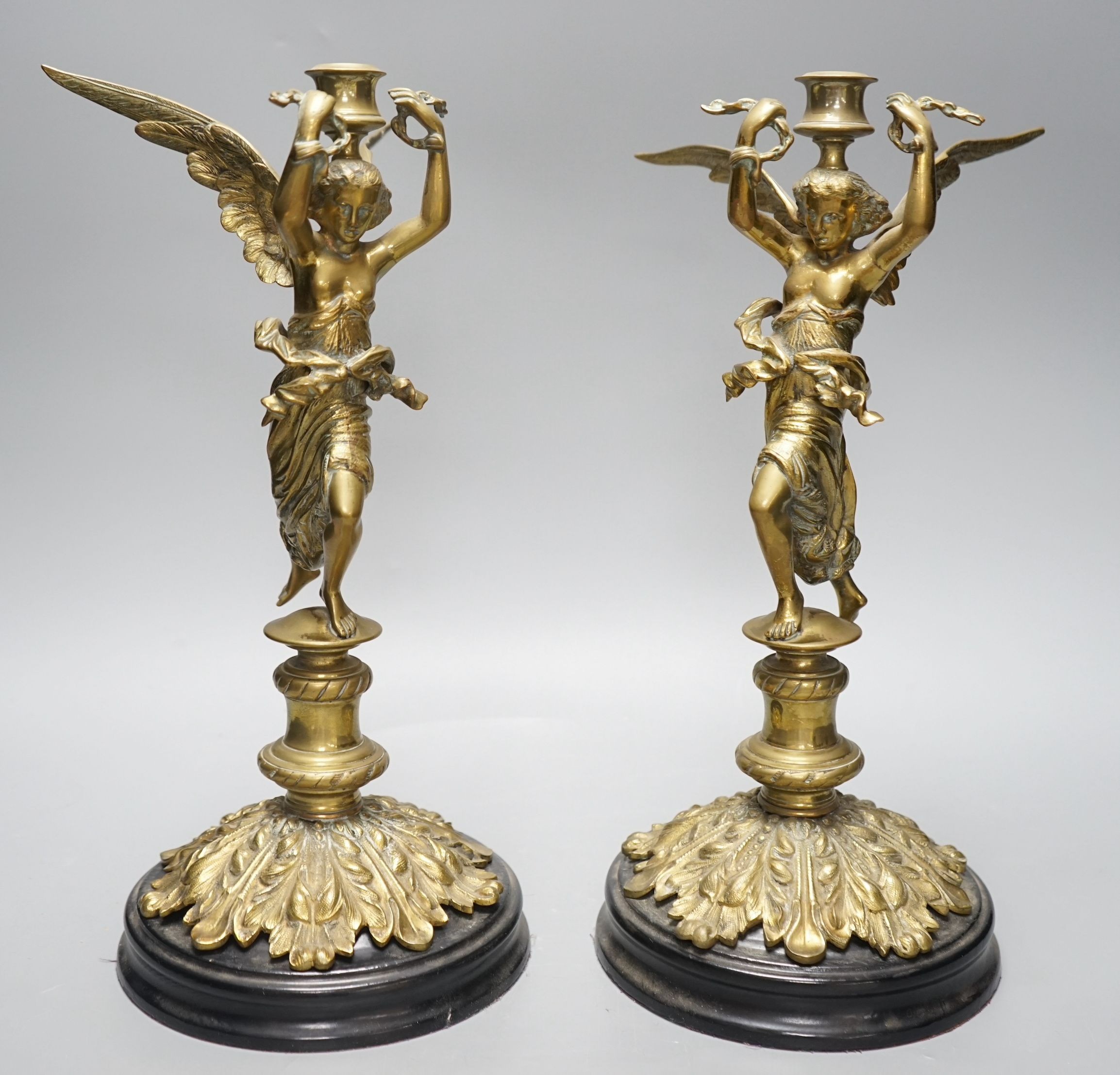 A pair of early 20th century cast brass ‘angel’ candlesticks, 36cms high